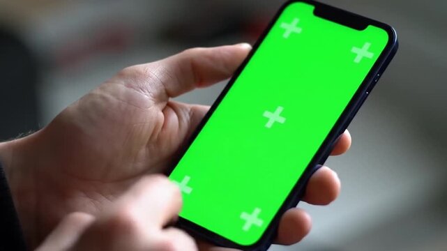 Hand holding green screen smartphone for digital app preview