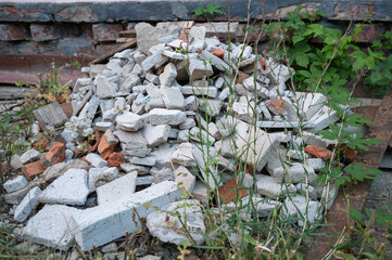 Piles of Construction Debris Surrounded by Weeds in an Abandoned Urban Landscape Area