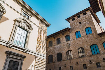 Obraz premium Shot of two old historic stone vintage buildings on a back alley in Florence, Firenze, Tuscany, Italy on a bright sunny clear summer day