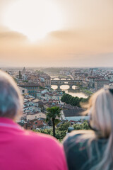Shot of Ponte Vecchio, Florence, Firenze, Tuscany, Italy at golden hour sunset with two tourists...