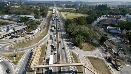 Transito com varios carros e caminhoes na dutra em movimento intenso, com fundo desfocado e imagem...