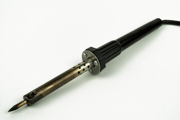 Close-up of an electric soldering iron with a metal tip, tool for electronnics repair and precision soldering, isolated on a clean background.