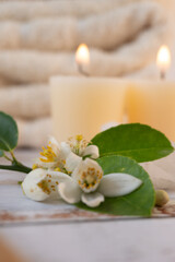 Close-up of orange blossoms, candles and towels in the background, spa atmosphere