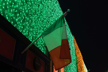 Mexican flag against festive downtown light display 