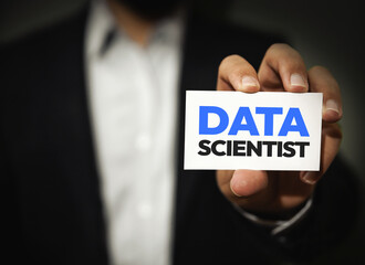 Data Scientist typography written on the card in the hand of a person showing. Hiring concept, learning, scientist hiring