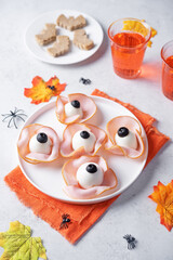 Halloween appetizer with eggs, black olives and ham in the form of eyes
