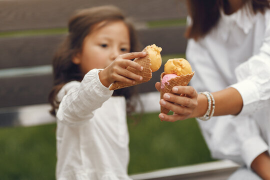 Mother with daughter eats ice cream in the city