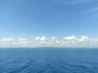 This scenic photograph presents a vast, open-water landscape under a clear blue sky. The deep blue...