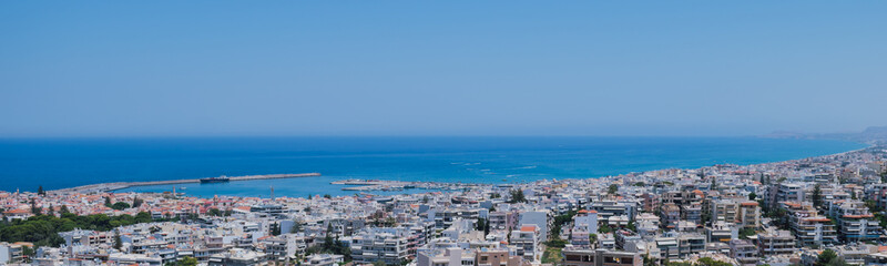 Fototapeta premium Panoramic view of the Greek city of Rethymno from a height on the island of Crete Greece. Residential buildings and the Aegean sea