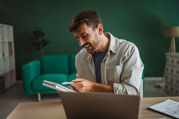 Entrepreneur working from home office reviewing notes and smiling