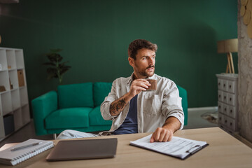 Adult stressed man abuses alcohol while working from home