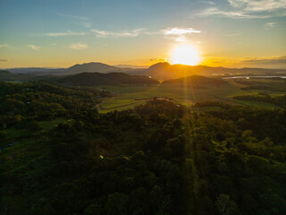 Fototapeta premium Aerial Sunset Over North Queensland Mountains and Farmland – Scenic Farmland Landscape, Misty Afternoon Light, Tropical Rural Beauty, Nature Photography, Australian Countryside, Farming Aerial View