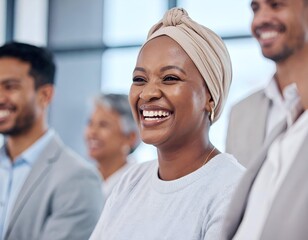 Diverse group of professionals attending a meeting, with a focus on a smiling Black woman in a headwrap, showcasing happiness and engagement in a modern office setting.