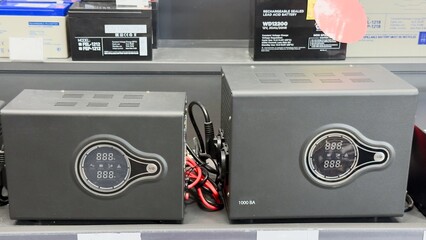 Battery chargers and sealed lead-acid batteries on a shelf — technical equipment for backup power systems, energy storage, and battery maintenance.