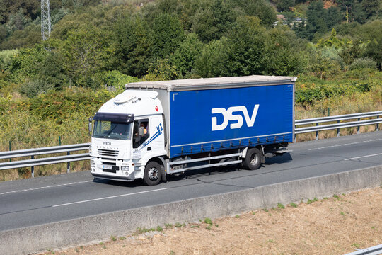 Pontevedra, spain 08 08 2025 dsv truck transporting goods on highway with lush green scenery