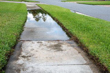 Water Floods a Sidewalk in a Neighborhood After Rainstorm