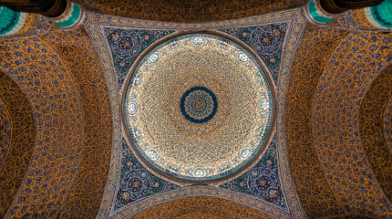 Intricate geometric patterns adorn an ornate domed ceiling, showcasing detailed Islamic architectural art in blue and gold.