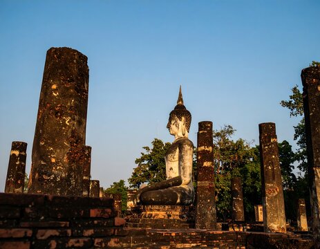 Ancient Buddha statue amidst weathered columns