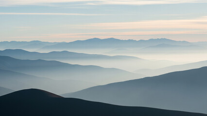 Fototapeta premium Mountain Vista in Haze: Gentle sunlight caresses distant mountain ridges, shrouded in a dreamy atmospheric haze, creating a serene and tranquil scene of natural beauty and calm.
