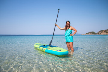 Sup boarding. An attractive young girl with sup board on the background of the sea. The concept of...