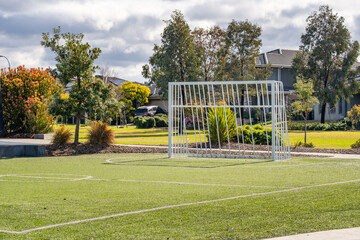 Obraz premium Small soccer or kids’ size goalpost on an artificial turf field in a community park. Point Cook, Melbourne, Australia. Concept of outdoor sports, recreational facilities and suburban active lifestyle