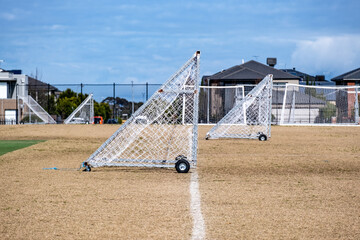 Portable soccer goalposts with wheels on a dry grass sports field in suburban residential neighborhood. Point Cook, Melbourne, Australia. Concept of community sports, recreational facilities © Doublelee