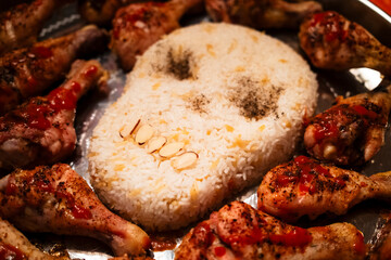 Creative dish featuring a skull-shaped rice centerpiece surrounded by chicken legs, decorated with spices and sauce for a spooky culinary presentation for halloween