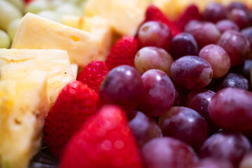 A vibrant assortment of fresh fruit, including strawberries, grapes, and pineapple, arranged deliciously for a refreshing treat