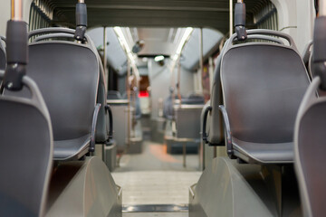 The interior design of the public transport vehicle reveals a row of empty seats ready for...