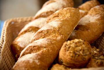 Warm, crusty bread and delicious pastries are arranged in a rustic woven basket, highlighting the craftsmanship of local bakers. The inviting aroma fills the air