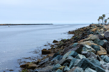 Mission Bay Entrance Channel near its exit to Pacific ocean with rocky shoreline covered in rough-hewn stones, San Diego, California
