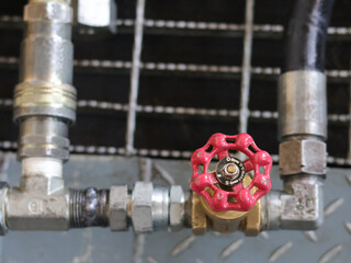 Industrial piping with red valves and brass with blur background.