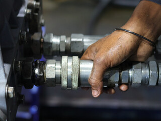 Close up of dirty mechanic's hand connecting quick coupler. Working concept