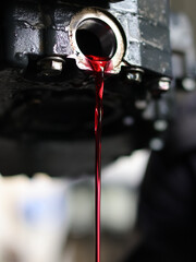 Auto mechanic loosen automatic transmission oil drain plug ,then let the old used automatic...