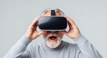 A shocked funny senior man with a white beard is amazed by his first experience in a virtual reality headset.