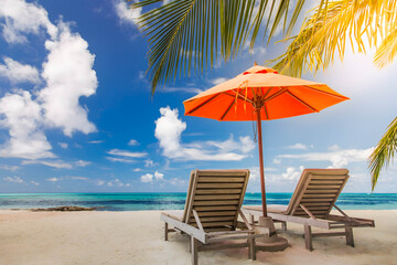 Idyllic summer scene with two wooden lounge chairs and an orange umbrella on a tropical beach, perfect for travel ads, vacation blogs, or summer holiday promotions