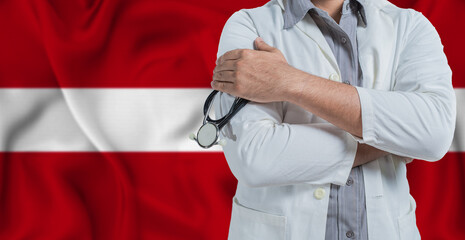 Doctor with stethoscope on arm with Latvia flag behind. National health system of Latvia, concept