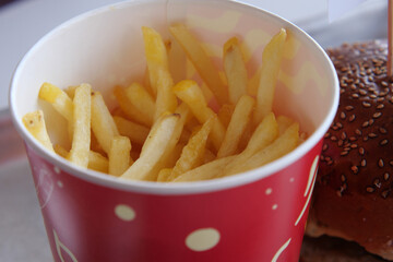 Crispy golden fries served in a red cup on a table