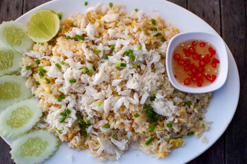 Thai style fried rice with pork, cucumber with chili in fish sauce in small cup on plate, Thai food.