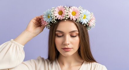 Naklejka premium Young woman with natural floral wreath poses against pastel background, displaying gentle beauty and springtime elegance, soft makeup and loose hair enhance her serene expression