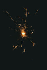Burning sparks flying. Beautiful flames. Fiery orange glowing flying away particles on black...
