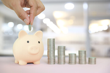 Hand and coin with piggy bank and pile coins stacked for growth real estate or money savings plan...