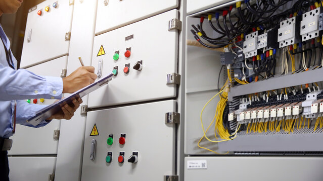 Electrician checking electric current voltage at circuit breaker terminal and cable wiring main power distribution board AHU starter control panel and Electricity or electrical maintenance service.