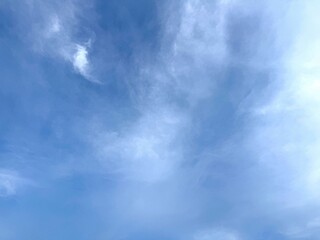 Tranquil atmosphere showcases a light blue daytime sky filled with soft wispy clouds