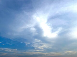 Bright daylight shines through the dynamic white and blue clouds creating atmospheric contrast