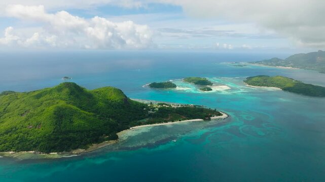 Tropical islands with turquoise waters, calm seas, and partly cloudy skies, viewed from above. Seychelles, Mahe. Ile au cerf island.