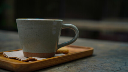 Cup of hot latte coffee with beautiful latte art topped with a butter cookie