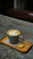 A close-up view of a cup of coffee with intricate latte art in the shape of a leaf