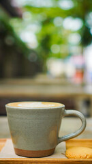 A close-up view of a cup of coffee with intricate latte art in the shape of a leaf