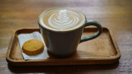 A close-up view of a cup of coffee with intricate latte art in the shape of a leaf